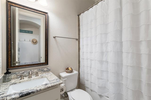 full bathroom featuring shower / tub combo, vanity, and toilet