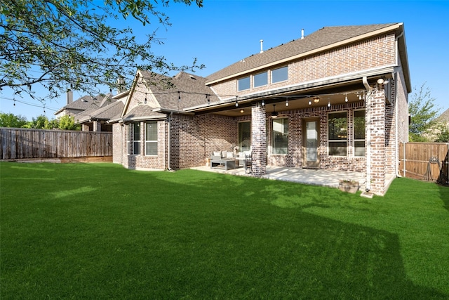 rear view of house featuring brick siding, a yard, and a fenced backyard