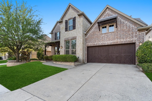 view of front of house featuring concrete driveway, a front lawn, stone siding, a garage, and brick siding
