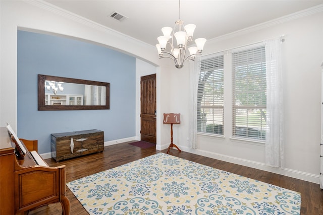 sitting room with dark wood finished floors, arched walkways, a notable chandelier, and crown molding