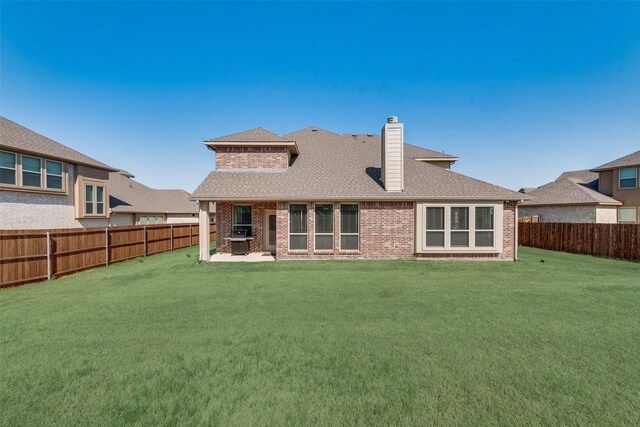 6517 Harwich Dr, Mesquite, TX 75181 - rear view of house featuring a shingled roof, brick siding, a fenced backyard, and a lawn