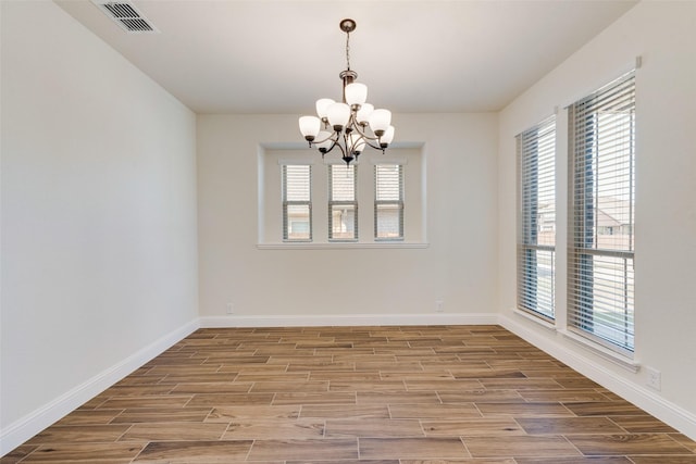 6517 Harwich Dr, Mesquite, TX 75181 - spare room featuring wood finished floors, a notable chandelier, visible vents, and a wealth of natural light