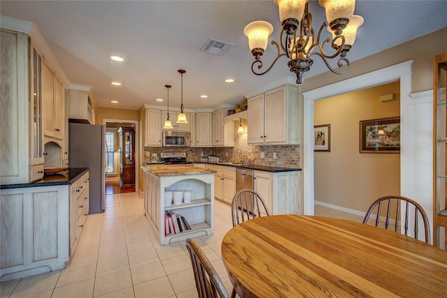 kitchen featuring appliances with stainless steel finishes, light tile patterned floors, open shelves, and visible vents