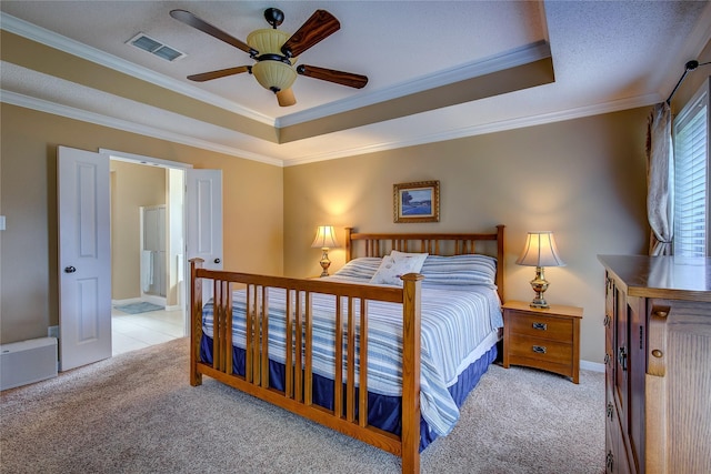 bedroom featuring crown molding, visible vents, a raised ceiling, and carpet