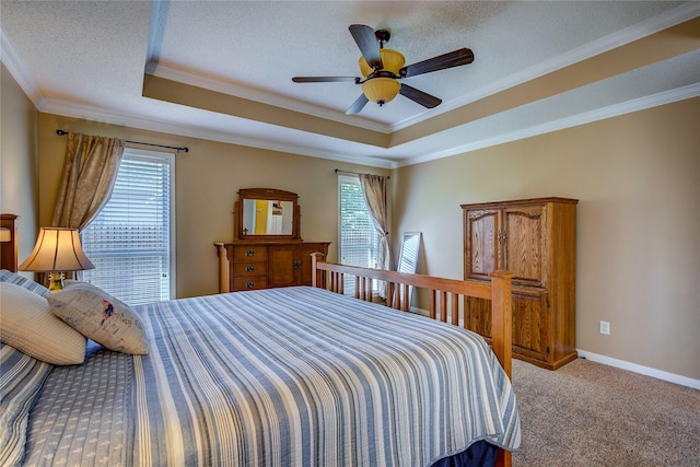 bedroom with a raised ceiling, crown molding, and multiple windows