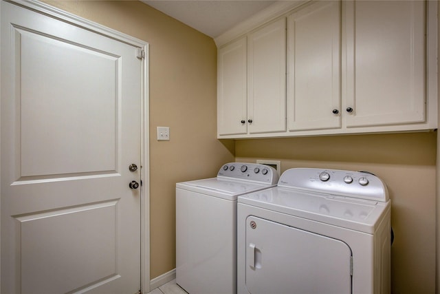 laundry area with washing machine and dryer, baseboards, and cabinet space
