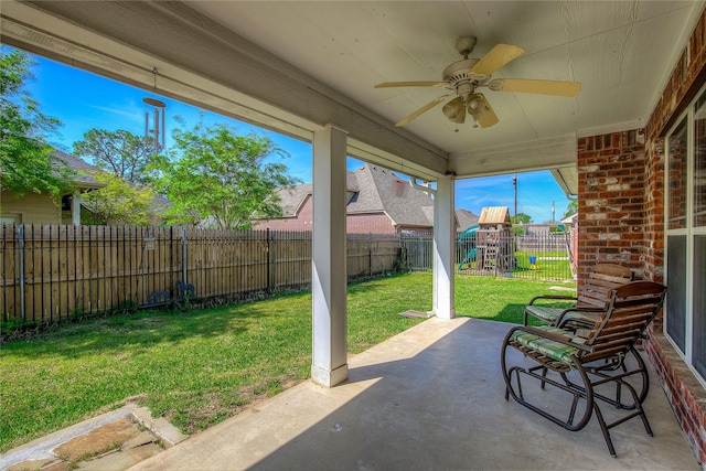 view of patio with a fenced backyard, a playground, and a ceiling fan