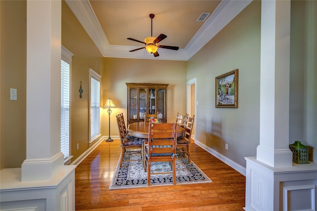 dining area featuring wood finished floors, ornamental molding, a ceiling fan, and visible vents