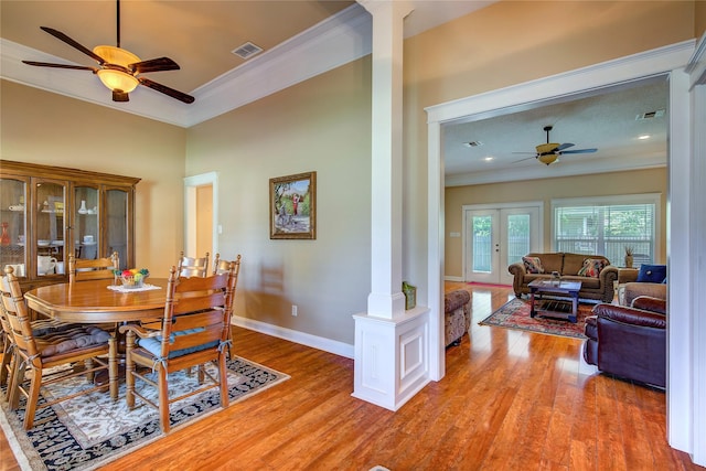 dining room featuring crown molding, ceiling fan, ornate columns, and light wood finished floors