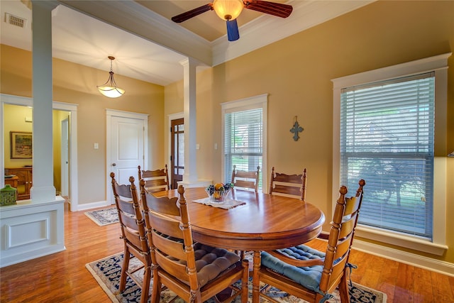 dining area featuring visible vents, light wood-style flooring, ornate columns, and a ceiling fan