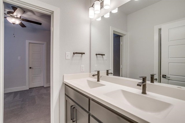 bathroom featuring a sink, ceiling fan, double vanity, and baseboards