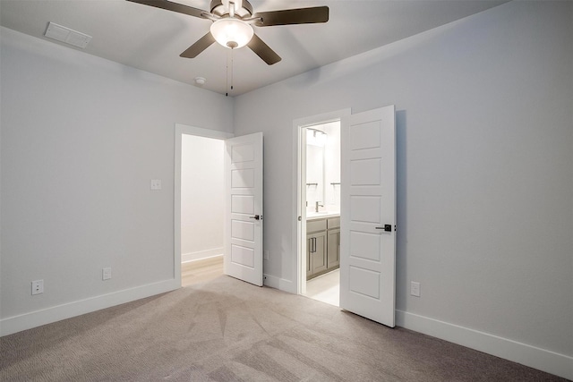 unfurnished bedroom with light carpet, baseboards, visible vents, and connected bathroom