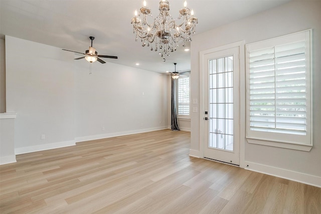 unfurnished dining area featuring recessed lighting, light wood-type flooring, ceiling fan with notable chandelier, and baseboards