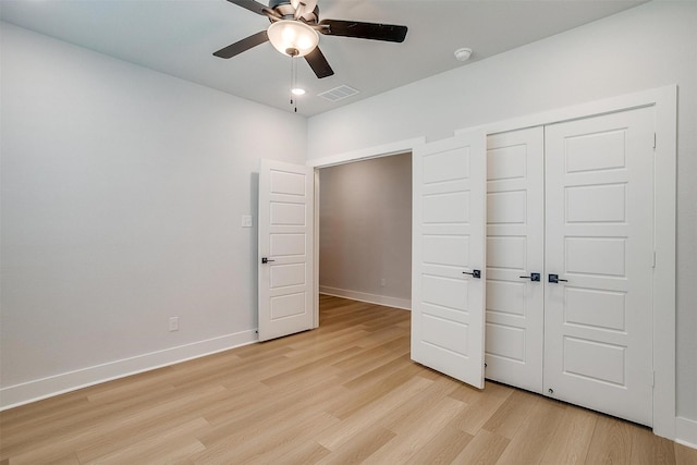 unfurnished bedroom featuring visible vents, baseboards, light wood finished floors, and a closet