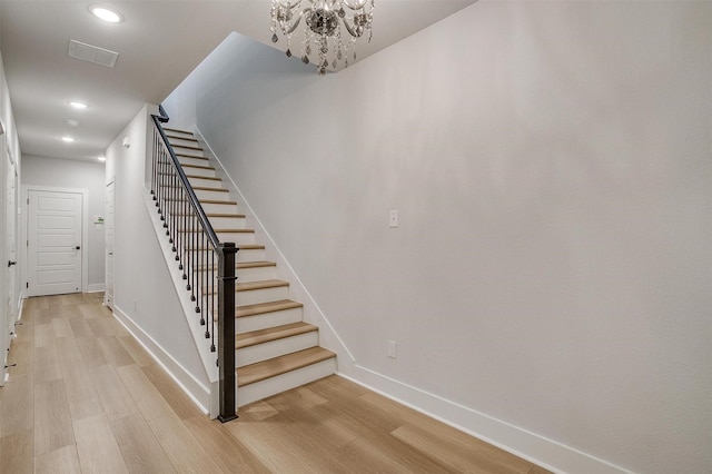 stairs with visible vents, baseboards, an inviting chandelier, recessed lighting, and wood finished floors