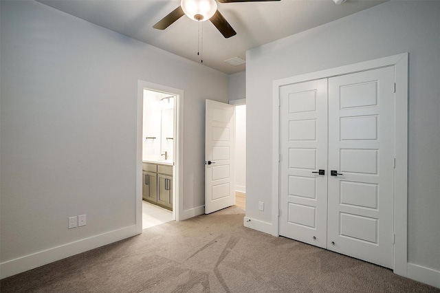 unfurnished bedroom with a closet, light colored carpet, ensuite bath, visible vents, and baseboards