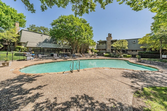 community pool featuring a patio and fence