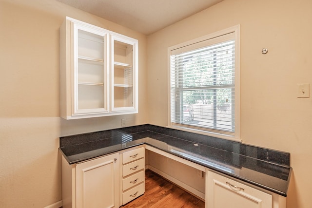 unfurnished office with built in desk and wood finished floors