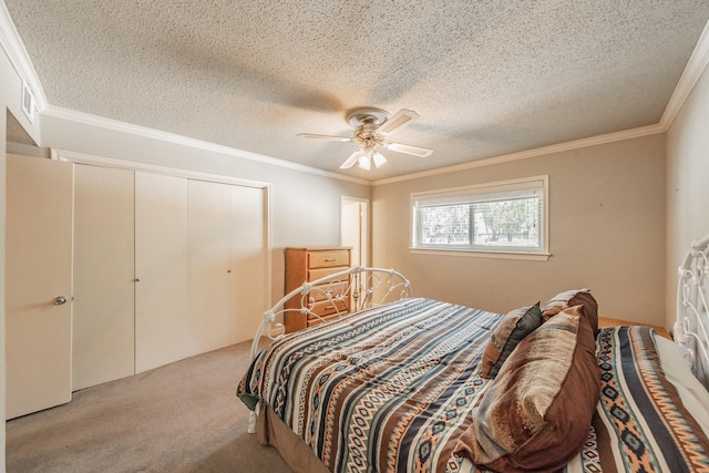 carpeted bedroom featuring a closet, a textured ceiling, a ceiling fan, and ornamental molding