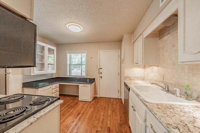 kitchen with glass insert cabinets, electric range oven, a sink, light wood-type flooring, and a textured ceiling