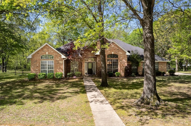 view of front facade featuring a front yard and brick siding