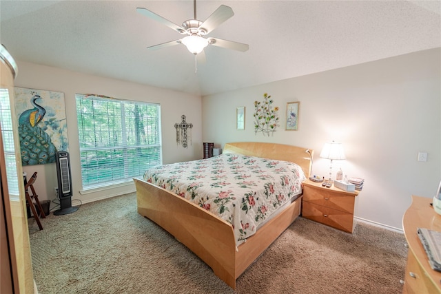 carpeted bedroom with baseboards, vaulted ceiling, and ceiling fan
