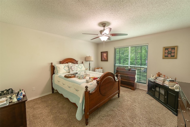 bedroom with baseboards, a ceiling fan, light colored carpet, and a textured ceiling