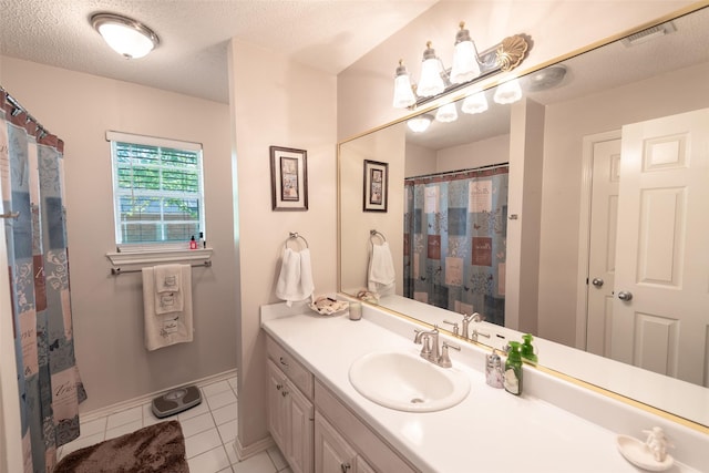 bathroom featuring tile patterned flooring, vanity, a textured ceiling, and visible vents