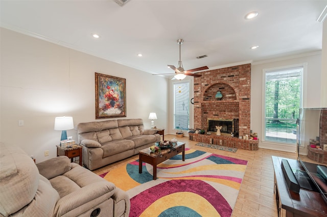 living room with visible vents, a ceiling fan, crown molding, recessed lighting, and light wood-style flooring