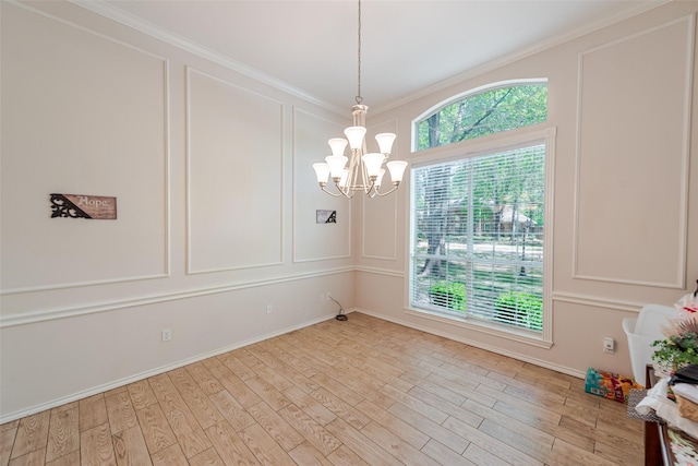 unfurnished dining area featuring a decorative wall, light wood-type flooring, ornamental molding, a notable chandelier, and baseboards