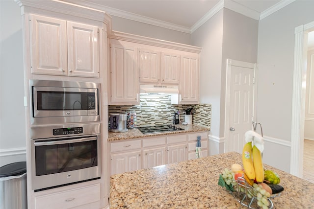 kitchen featuring stainless steel microwave, tasteful backsplash, black electric stovetop, under cabinet range hood, and light stone countertops