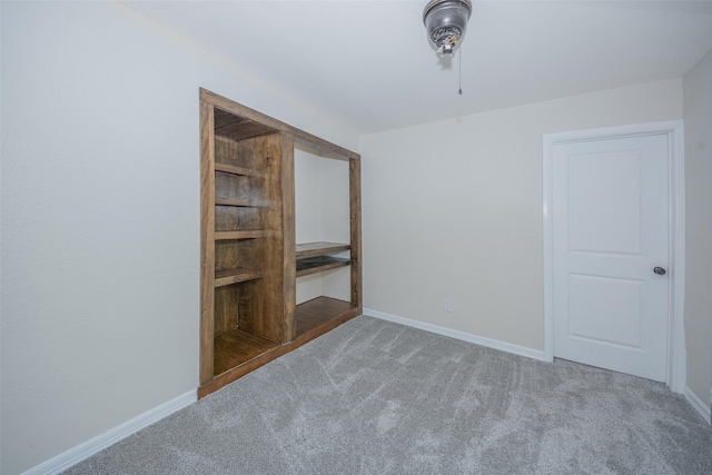 carpeted empty room with baseboards and a ceiling fan