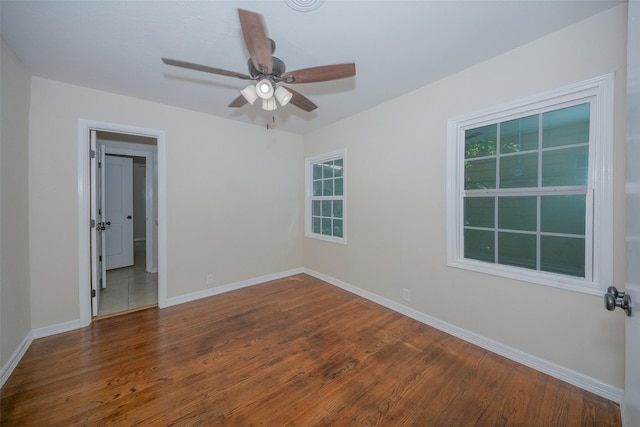 spare room featuring ceiling fan, baseboards, and wood finished floors