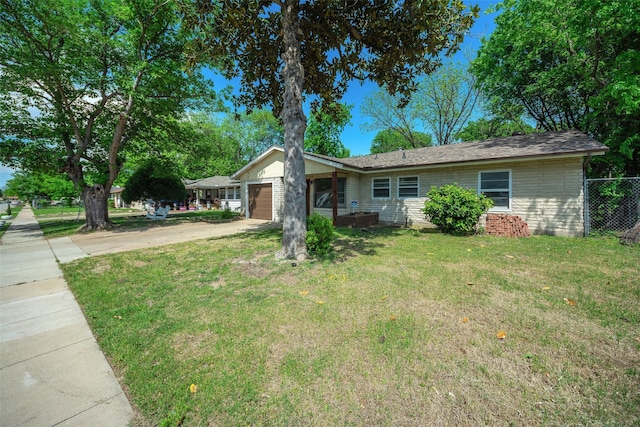 ranch-style home featuring an attached garage, driveway, fence, and a front lawn