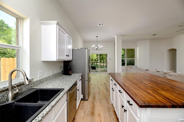 3945 Ringdove Way, Fort Worth, TX 76262 - kitchen featuring a sink, butcher block counters, appliances with stainless steel finishes, light wood-style floors, and open floor plan