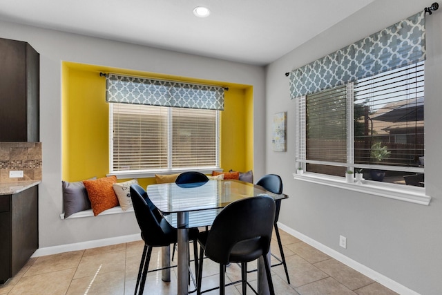 dining space with light tile patterned floors, baseboards, and plenty of natural light
