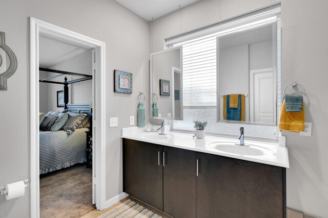 bathroom with double vanity, ensuite bath, and a sink