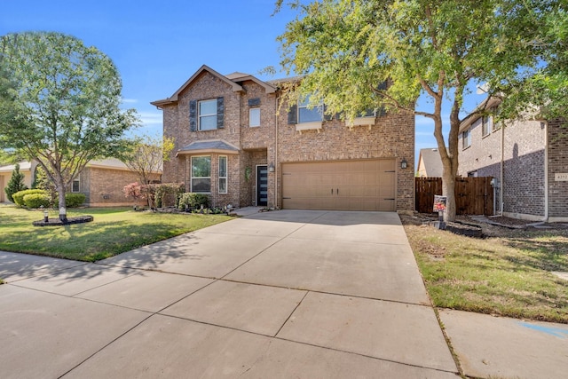 view of front of home with a front yard, fence, brick siding, an attached garage, and driveway