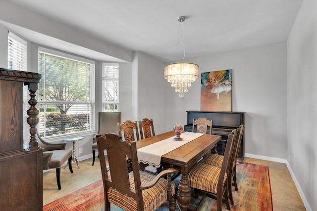 dining space with light tile patterned floors, a notable chandelier, and baseboards