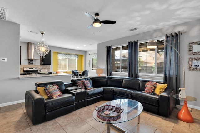 living room featuring visible vents, baseboards, light tile patterned floors, and ceiling fan with notable chandelier