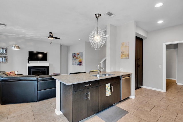 kitchen with a glass covered fireplace, a ceiling fan, visible vents, dishwasher, and a sink