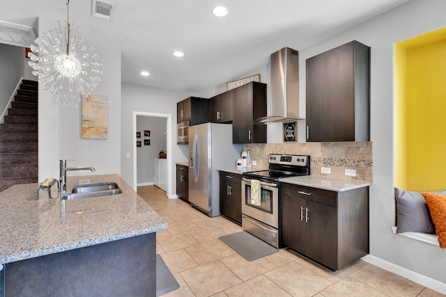 kitchen featuring visible vents, wall chimney exhaust hood, a sink, dark brown cabinets, and stainless steel appliances