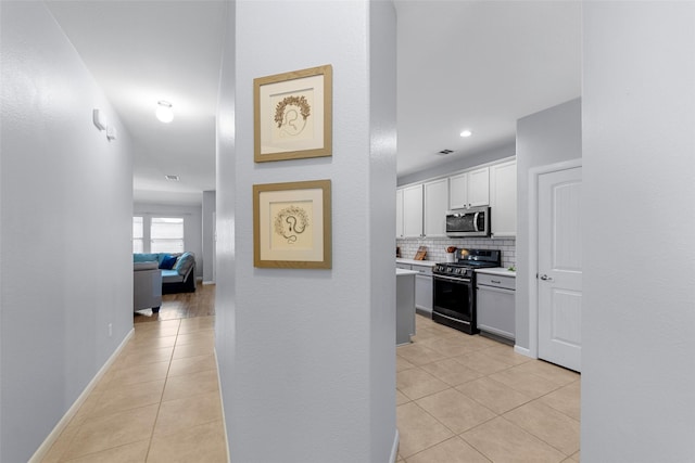 hall featuring visible vents, baseboards, recessed lighting, and light tile patterned flooring