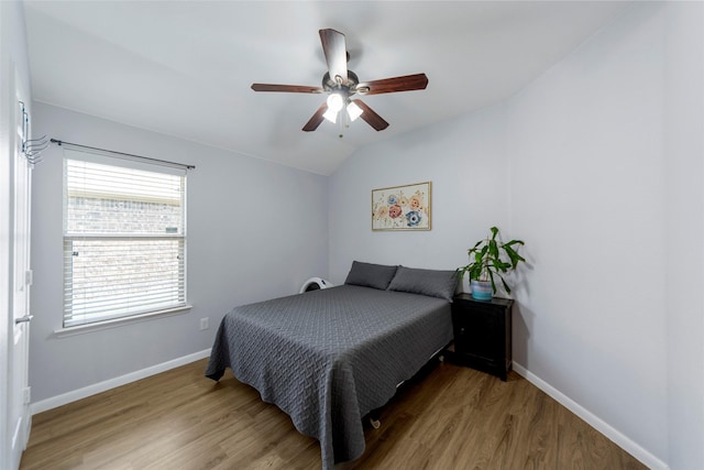 bedroom with ceiling fan, baseboards, vaulted ceiling, and wood finished floors