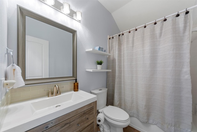 full bath featuring tasteful backsplash, shower / bath combination with curtain, toilet, vanity, and vaulted ceiling