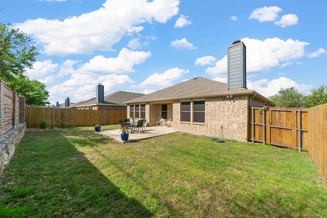 back of house featuring a yard, a fenced backyard, and a patio
