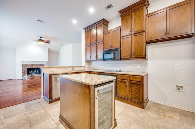 9133 Wichita Trl, Frisco, TX 75033 - kitchen with a ceiling fan, a center island, black appliances, brown cabinets, and wine cooler