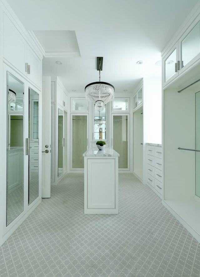 spacious closet featuring light carpet and a notable chandelier