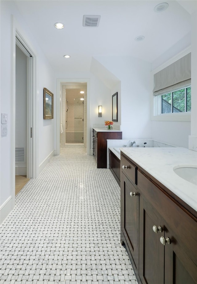 full bathroom featuring two vanities, visible vents, a sink, and a stall shower