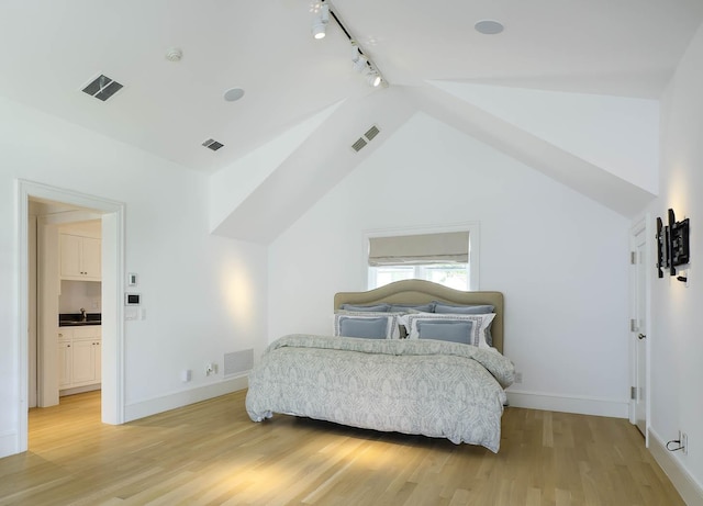 bedroom featuring light wood-type flooring, a sink, rail lighting, and visible vents